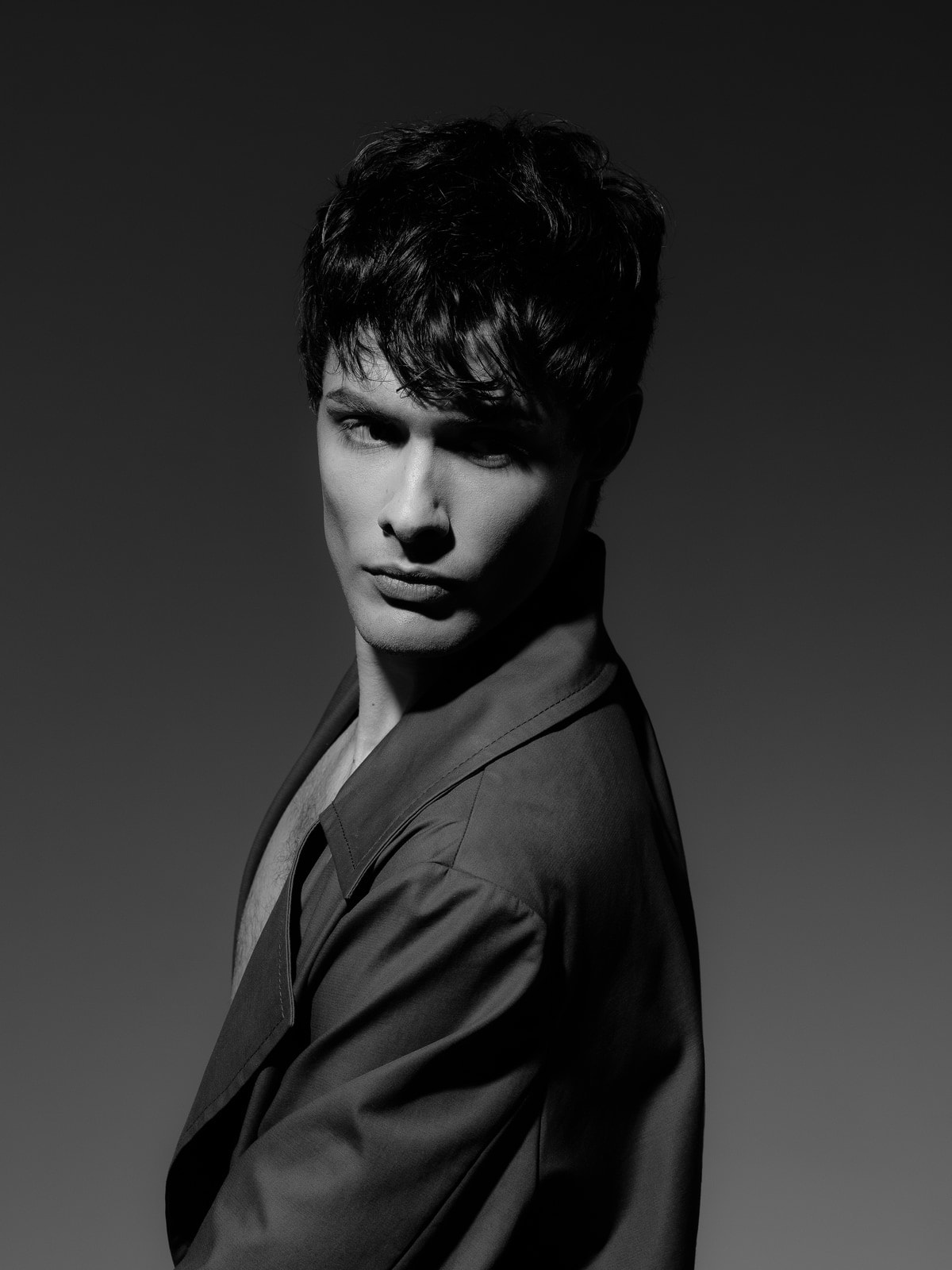 Backward glance over a raised collar, dark fringe crossing one eye